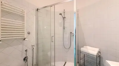 a bathroom with a shower with a glass door at Beautiful apartment within walking distance of the Vatican in Rome
