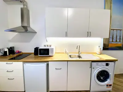 a white kitchen with a sink and a microwave at Karma Trastevere Loft in Rome