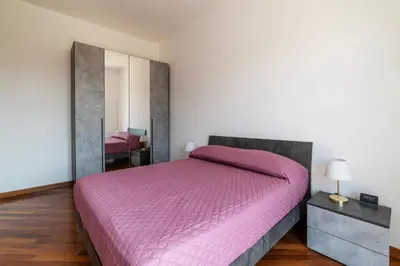 a bedroom with a pink bed and a mirror at GuestHost - Bright Apartment in Metro San Giovanni in Rome
