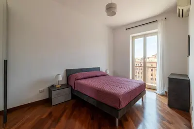 a bedroom with a bed and a large window at GuestHost - Bright Apartment in Metro San Giovanni in Rome