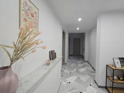a hallway with white walls and a vase with flowers at Rome sweet home - Casa Cesari in Rome