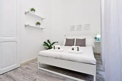 a white bedroom with a large white bed in it at DaliTourism - Colosseo Experience 28 in Rome