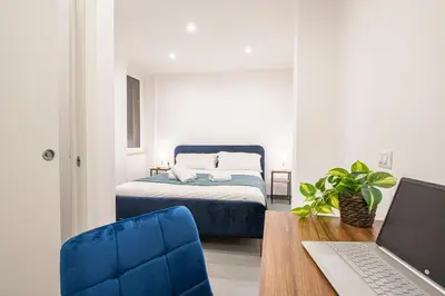 a bedroom with a bed and a desk with a laptop at Pallaro 6 room in Rome