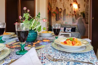 a table with plates of food and glasses of wine at Azzurra Home in Rome
