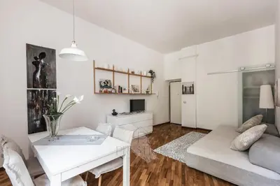 a white living room with a table and a couch at Vatican Gallery Apartment in Rome
