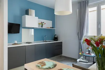 a kitchen with blue walls and a sink and a table at Now Apartments, ApartHotel in the heart of Rome in Rome