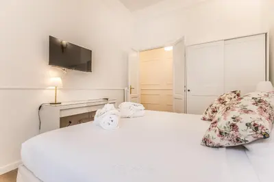 a white bedroom with a large white bed with pillows at Elegant 3-bedroom apartment near the Metro in Rome
