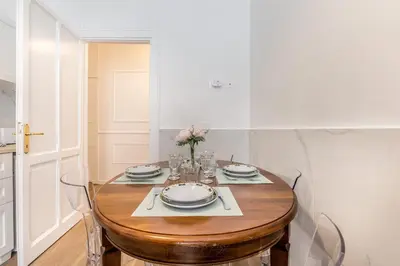 a dining room table with a vase of flowers on it at Elegant 3-bedroom apartment near the Metro in Rome