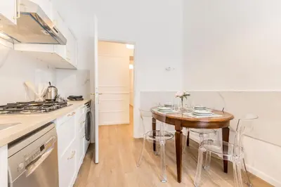 a kitchen with a wooden table and a small table with chairs at Elegant 3-bedroom apartment near the Metro in Rome