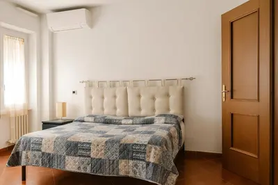 a bedroom with a bed with a tufted headboard at La Casa del Viaggiatore in Rome