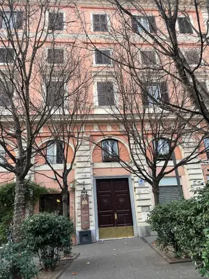 a large brick building with a brown door and trees at Refined two-bedrooms Roman Residence in Rome