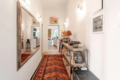a hallway with a mirror and a rug at Refined two-bedrooms Roman Residence in Rome