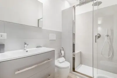 a white bathroom with a toilet and a shower at Elegant and spacious apartment facing the subway near the Vatican in Rome