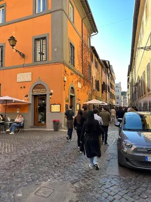 a group of people walking down a street at Home Delfini in Trastevere in Rome