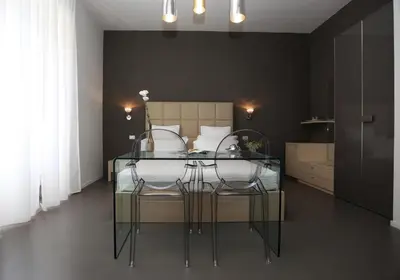 a bedroom with a bed with a glass table and chairs at Residenza Crescenzio in Rome
