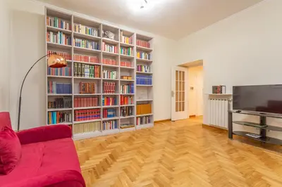 a living room with a red couch and book shelves at Easybnb - Daisy in Rome