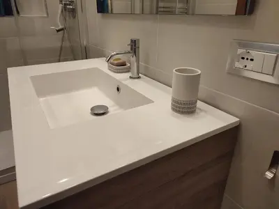 a white sink in a bathroom with a mirror at Tanner's Apartment - Piramide in Rome