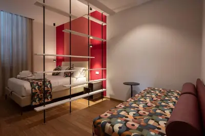 a bedroom with a bed and a red wall at New Roman Experience in Rome