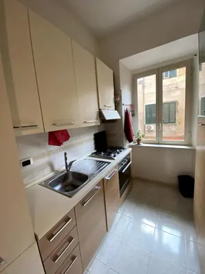 a kitchen with white cabinets and a sink and a window at Small and very small house in Rome