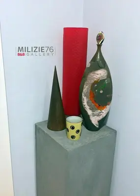 two vases and a cup sitting on a block at Milizie 76 Gallery in Rome
