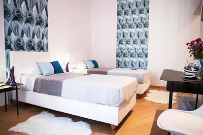 a bedroom with two beds and a table at Milizie 76 Gallery in Rome