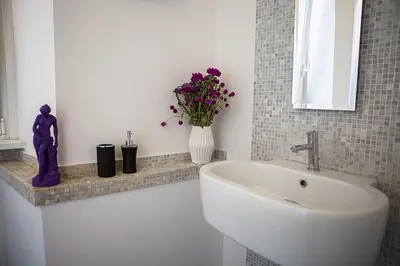 a bathroom with a sink and a vase of flowers at Milizie 76 Gallery in Rome