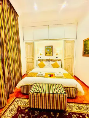a hotel room with a large bed with two ottoman at Fori Imperiali Colosseum in Rome