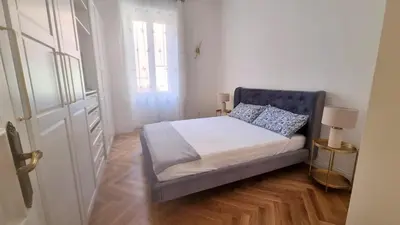 a small bedroom with a bed with a blue chair at Beautiful Apartment San Pietro in Rome