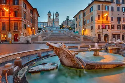 a fountain in the middle of a city with buildings at Casa Amicitia Piazza di Spagna in Rome