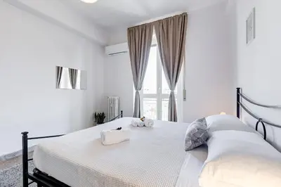 a white bedroom with a large bed with a window at L'oasi romana di Daniela in Rome