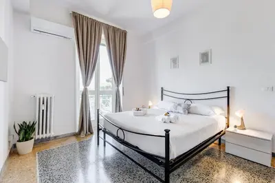 a bedroom with a bed with white sheets and a window at L'oasi romana di Daniela in Rome