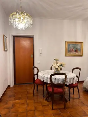 a dining room with a table and chairs and a chandelier at A casa di Tony in Rome