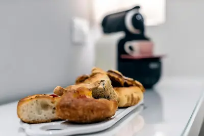 a plate of pastries and bread on a counter at Bella Roma Luxury Accommodation, Vatican City - Liberty Collection in Rome