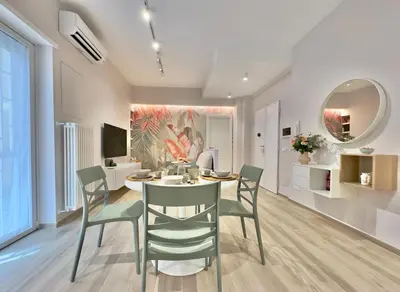 a dining room with a table and chairs and a mirror at Casa Colli in Rome