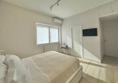 a white bedroom with a large bed and a window at Casa Colli in Rome