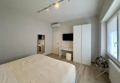 a white bedroom with a bed and a television at Casa Colli in Rome