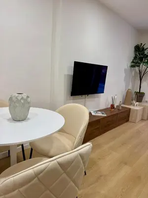 a living room with a white table and chairs and a tv at Scala 36, Trastevere, Rome in Rome