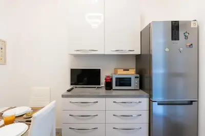 a kitchen with a stainless steel refrigerator and a table at Imperial House - 300m to Metro B, Open view, 4-6pax in Rome