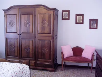 a bedroom with a large wooden cabinet and a chair at Apartment in the center of Rome with spectacular view of the Dome in Rome