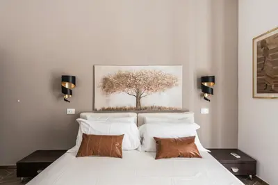 a bedroom with a white bed with a tree painting on the wall at 59 Riverside in Rome