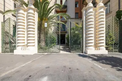 an entrance to a building with a gate with palm trees at Incanto al Colosseo - Terrace retreat in Rome