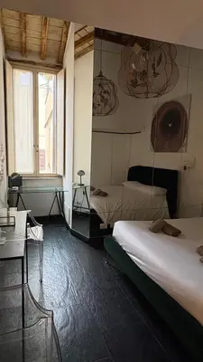 a hotel room with two beds and a window at Monti luxury penthouse in Rome