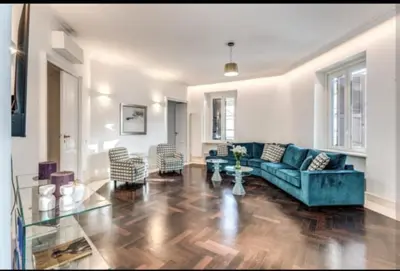 a living room with a blue couch and chairs at Barberini Apartment in Rome