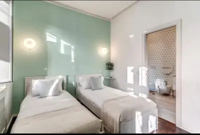 two beds in a room with green walls at Barberini Apartment in Rome