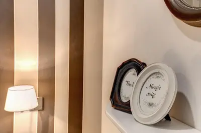 a clock sitting on a shelf next to a lamp at Trevi Miracle Suite in Rome
