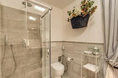 a bathroom with a toilet and a glass shower at Trevi Miracle Suite in Rome