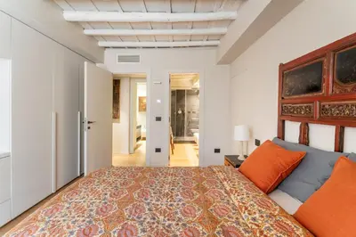 a bedroom with a large bed with orange pillows at Zenaria Trastevere, Zen Design in Heart of Rome in Rome