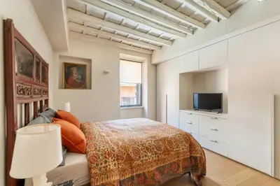 a bedroom with a bed and a tv at Zenaria Trastevere, Zen Design in Heart of Rome in Rome