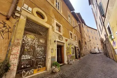 an alley with graffiti on the side of a building at Al moro in Rome