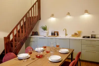 a kitchen with a wooden table with plates and wine glasses at Daplace - Serenella Apartment in Rome